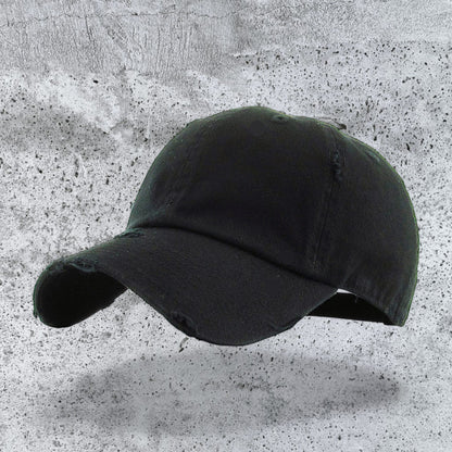 KB unstructured baseball cap, black distressed cotton low profile crown, front left view on textured background